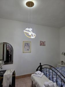a bedroom with a bed and a chandelier at Casa Grilla in Assemini +3 photos