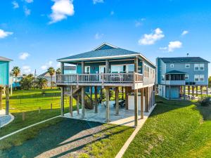 a large house with a deck on a lawn at Steps to the Beach l Modern Interior in Crystal Beach