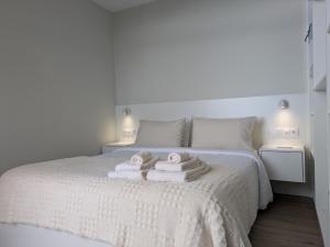 a bedroom with a bed with towels on it at Monte Gordo Accommodation in Ribeira Brava