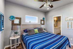 a bedroom with a bed and a ceiling fan at Steps to the Beach l Modern Interior in Crystal Beach