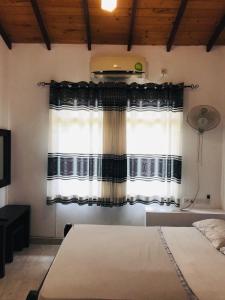 a bedroom with a bed and a window at Madusanka Holiday Home in Gomagoda