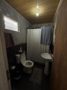 a bathroom with a toilet and a sink at Casa del parque in Oberá +4 photos