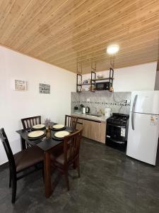 a kitchen with a dining table and a refrigerator at Casa del parque in Oberá