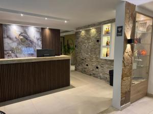 a bar in a hotel lobby with a stone wall at Arcadia Hotel in Cartagena de Indias