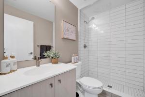 a white bathroom with a toilet and a sink at Propercare - The Wellingtons in Kitchener +72 photos