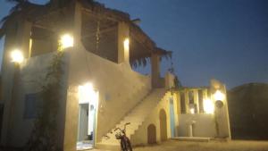 a building with a staircase with lights on it at Fekry house in Qaryat Ḩātim aţ Ţāʼī