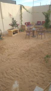 a patio with tables and benches in the dirt at Fekry house in Qaryat Ḩātim aţ Ţāʼī +3 photos