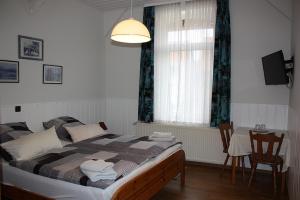 a bedroom with a bed and a table and a window at Agardy,s Landgasthof in Holle