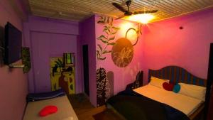a bedroom with a bed and a pink wall at The Rawscape Hostel in Kausani +98 photos