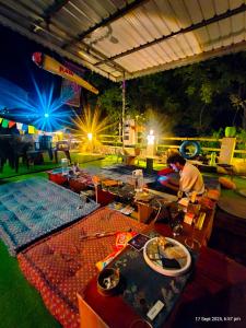 a man is working on a table at an event at The Rawscape Hostel in Kausani
