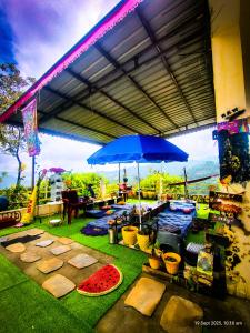 an outdoor patio with a table and an umbrella at The Rawscape Hostel in Kausani