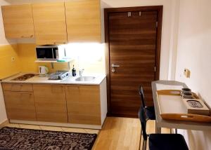 a small kitchen with a sink and a wooden door at Donovaly Kamzík in Donovaly +10 photos