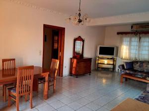 a living room with a table and a television at Enjoy The Silence in Svoronata