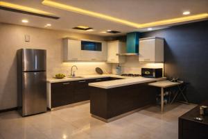 a kitchen with a stainless steel refrigerator and cabinets at The Nest Apartment in Rawalpindi