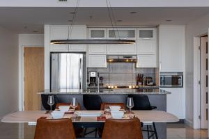 a dining room with two tables and chairs and a kitchen at Les Immeubles Charlevoix - Le 760-415 in Quebec City