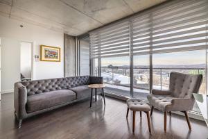 a living room with a couch and a table and chairs at Les Immeubles Charlevoix - Le 760-415 in Quebec City