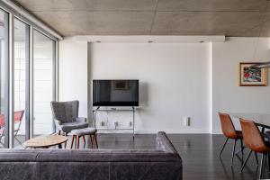 a living room with a couch and chairs and a tv at Les Immeubles Charlevoix - Le 760-415 in Quebec City
