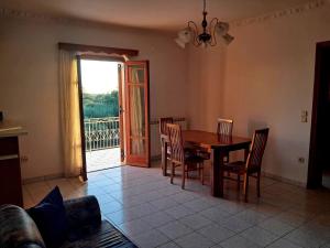 a dining room with a table and chairs and a balcony at Enjoy The Silence in Svoronata