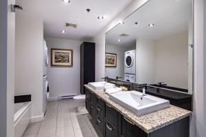 a bathroom with two sinks and a large mirror at Les Immeubles Charlevoix - Le 760-415 in Quebec City +11 photos