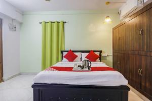 a bedroom with a large bed with red pillows at Hotel O RR in Kondapur
