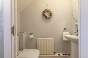 a white bathroom with a toilet and a sink at 2 Bed in Beadnell oc-gd0376 in Beadnell +8 photos