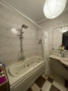 a white bathroom with a tub and a sink at Cozy Private Room with Jacuzzi Maadi in Cairo