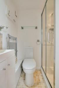 a white bathroom with a toilet and a shower at 4 Bed in Reydon oc-fll in Reydon +7 photos
