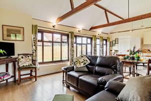 a living room with a leather couch and a table at 1 Bed in St. James South Elmham Halesworth oc-t27361 in Saint James
