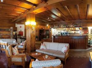 a restaurant with couches and a bar with a counter at Hotel Bosco Verde in Mareson