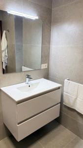 a bathroom with a white sink and a mirror at Puerta del Mar 2 in Adra