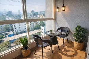 a table and chairs in a room with windows at Sylevo 2bhk Baner in Pune