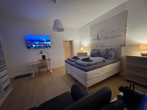 a living room with a couch and a flat screen tv at 35qm2, Whirlpool & Queensize-Bett, Terrasse 50qm2, Self-Checkin, eigener Parkplatz, Nähe Ulm und Universität in Blaustein +13 photos
