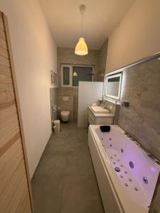a bathroom with a tub and a toilet and a sink at 35qm2, Whirlpool & Queensize-Bett, Terrasse 50qm2, Self-Checkin, eigener Parkplatz, Nähe Ulm und Universität in Blaustein