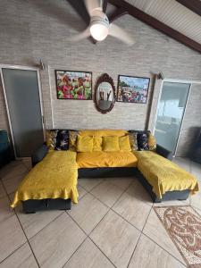 a bedroom with two beds and a ceiling fan at residence caramboles in Fort-de-France
