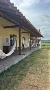 a house with hammocks on the porch of it at Tupinambá Pousada e Hostel in Caraíva