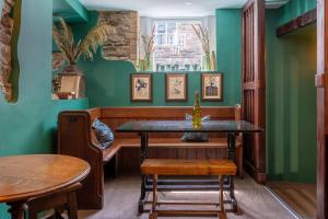 a dining room with green walls and a table and chairs at Tithe Barn - Self Check In Hotel in Cockermouth