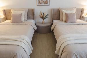 a room with two beds with pillows and a table at Dreiländer-Blick Apartment 2 Schlafzimmer in Lörrach
