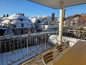 a balcony with a table and chairs and snow covered mountains at Coraline -Koblach, 6-10 P, 3 Schlafzimmer, Küche, riesige Terrasse, Parkplatz, WiFi, Stellplatz Ski in Koblach