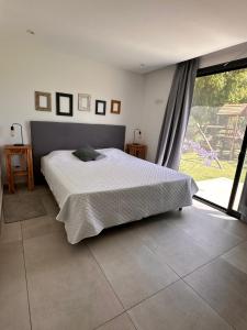 a bedroom with a bed and a large window at La Antonieta in Brandsen