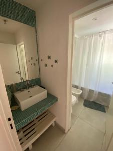 a bathroom with a sink and a toilet and a mirror at La Antonieta in Brandsen +4 photos