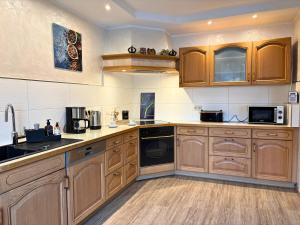 a large kitchen with wooden cabinets and appliances at Ferienhaus Landeskrone für 10 Personen mit Sauna, Terrasse, inkl Parkplatz in Dresden in Dresden