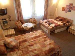 Penzion Vlasta في هرينسكو: غرفة نوم بسرير وطاولة وكراسي