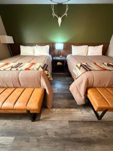 a hotel room with two beds and a bench at Ninepipes Lodge in Polson +121 photos