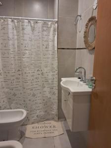 a bathroom with a shower curtain with writing on it at Monoambiente zona UNNE in Resistencia +8 photos