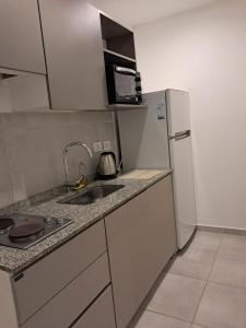 a small kitchen with a sink and a refrigerator at Monoambiente zona UNNE in Resistencia