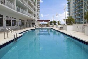 a large swimming pool with chairs and a building at Luxury Apartment in Brickell in Miami