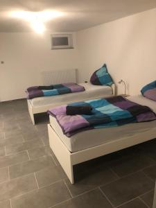 two beds sitting in a room with tile floors at Chambrette bei Kassel in Eiterhagen