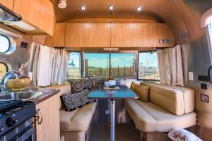 an rv with a couch and a table in it at The Outpost Grand Canyon in Williams
