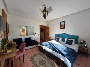 a bedroom with a king sized bed and a couch at Private pool villa & garden Marrakech in Marrakesh