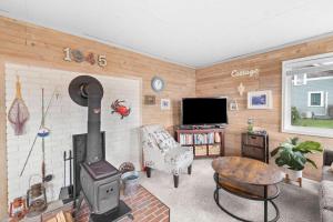 a living room with a wood stove and a tv at Coho Cottage in Rockaway Beach